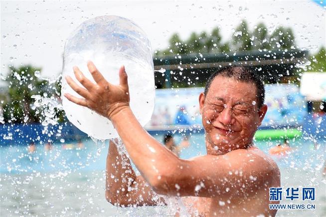8月16日,一位重庆市民在红酒小镇水公园内手抱冰块消暑降温.
